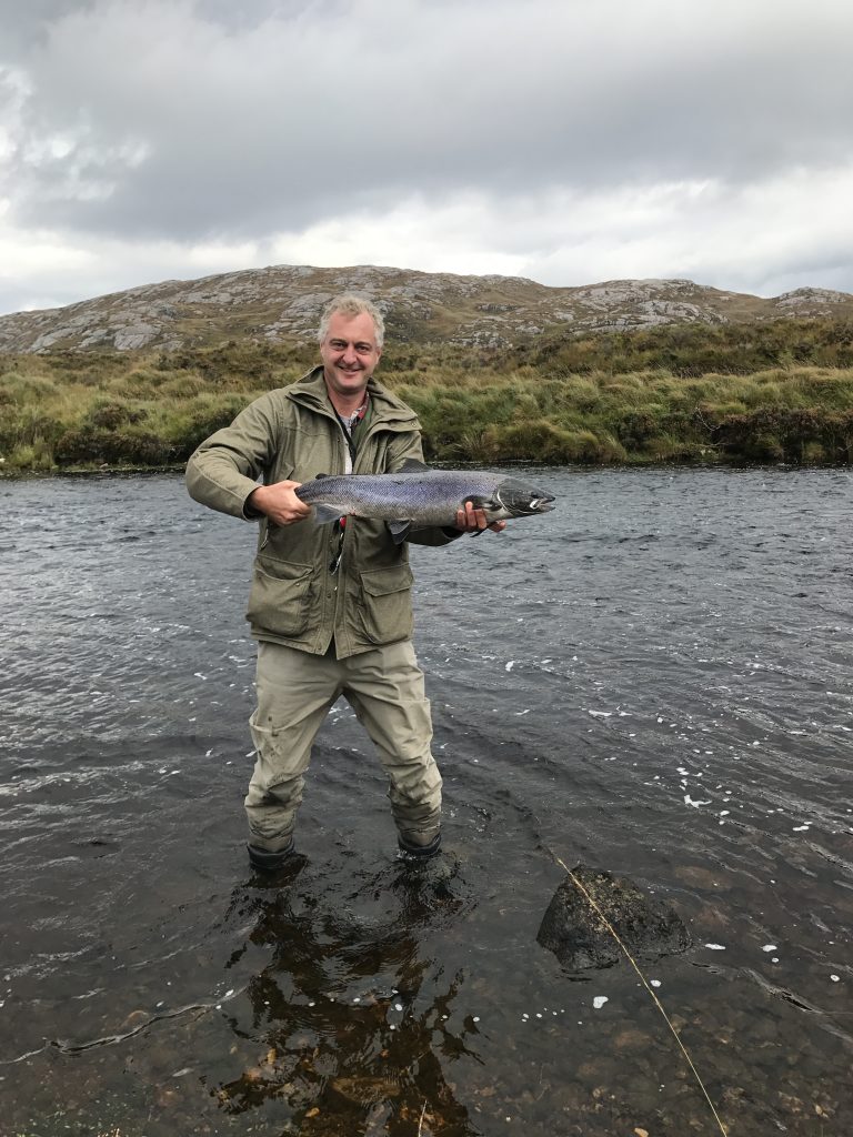 Hamish in river holding salmon