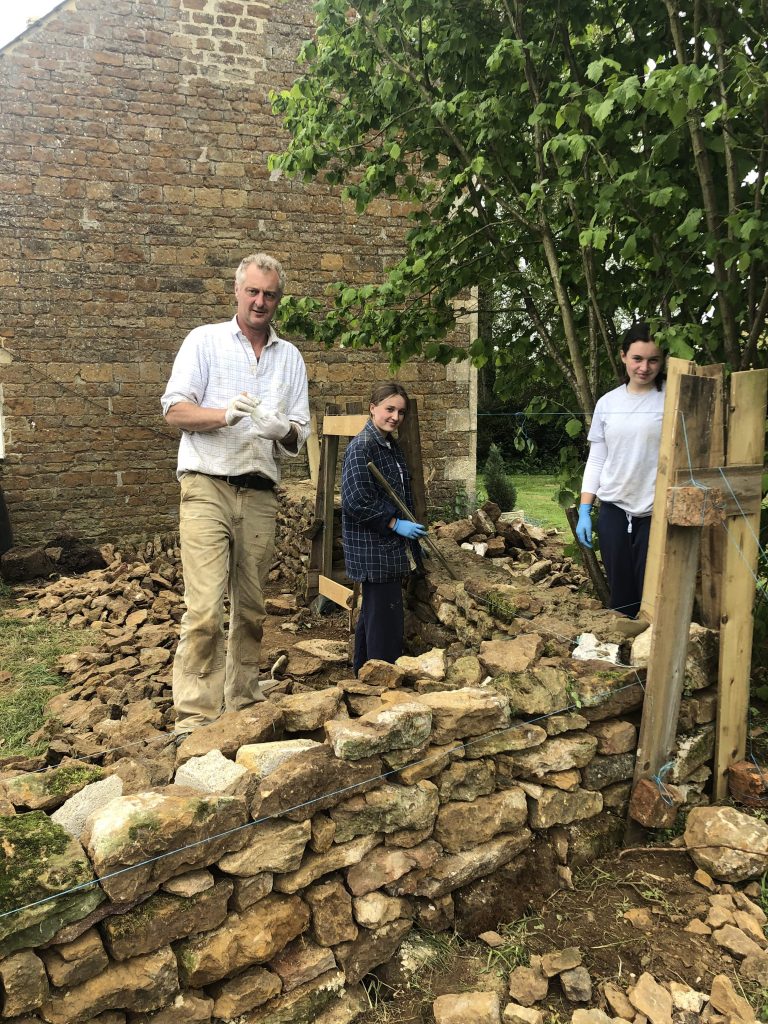 Hamish and his daughters building a wall