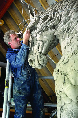 Knight Frank magazine shows picture of Hamish working on horse sculpture