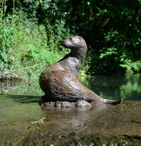 bronze otter sculpture in water