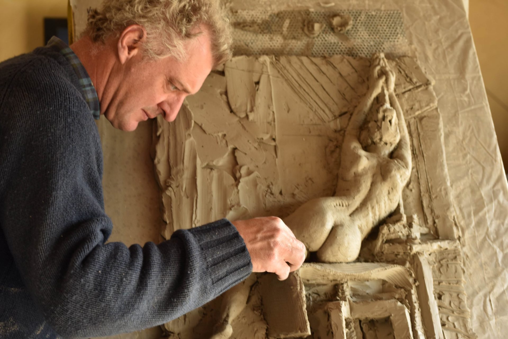Hamish sculpting a figurative relief sculpture