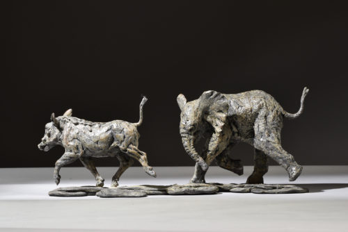 elephant calf chasing warthog sculpture