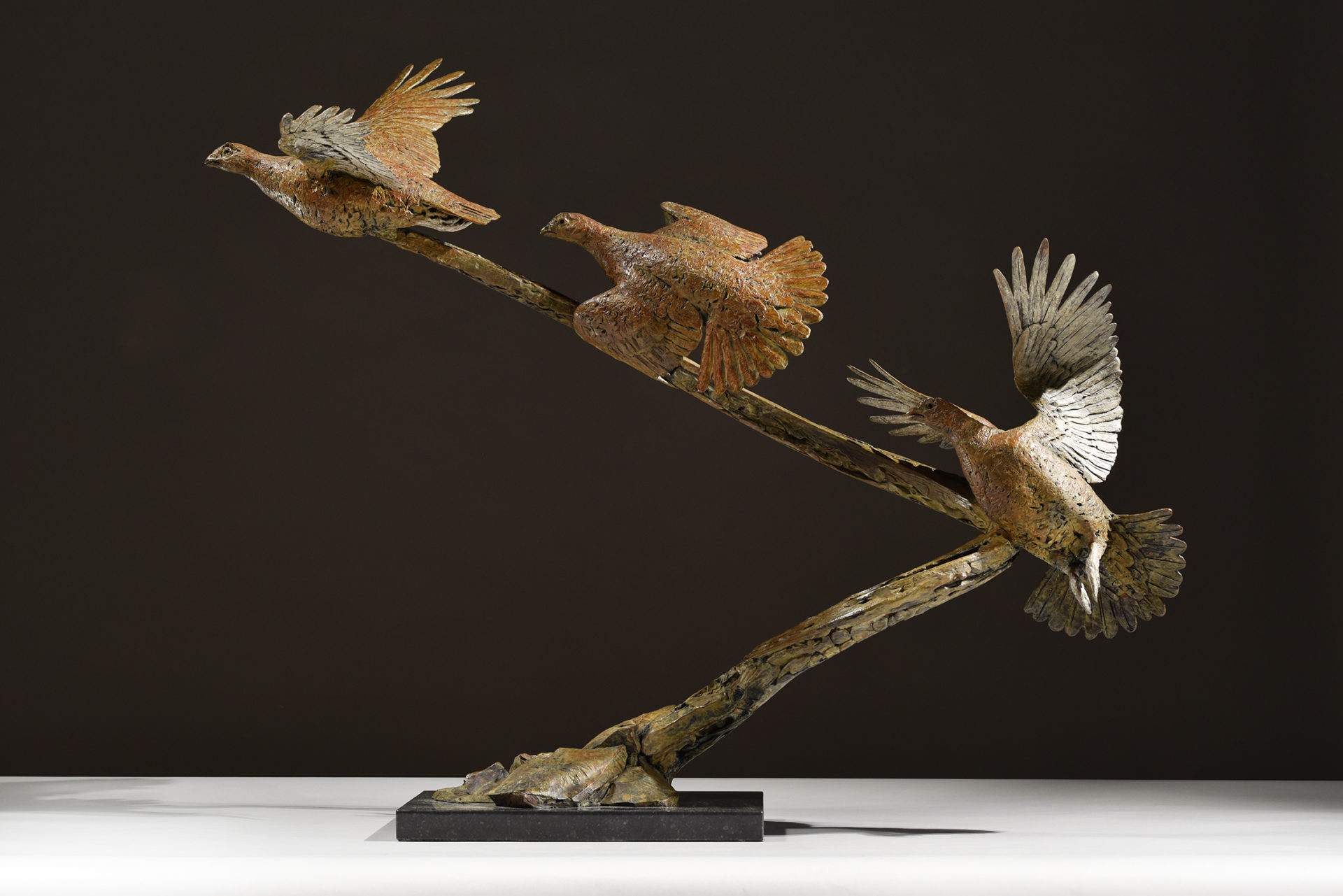 bronze sculpture of grouse flushing