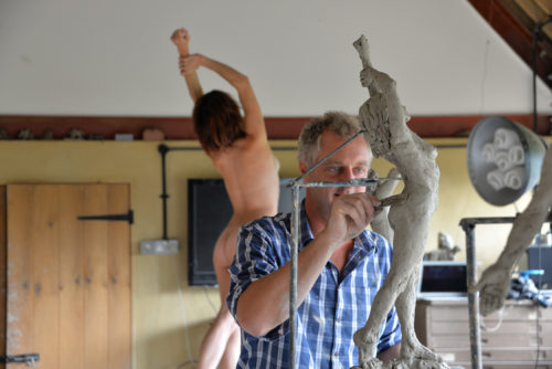 Hamish sculpting nude stretching female in studio