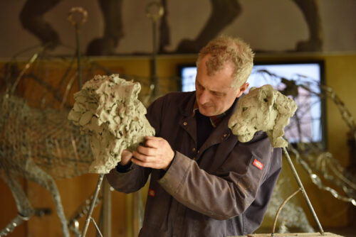 Hamish making lioness and lion head sculpture
