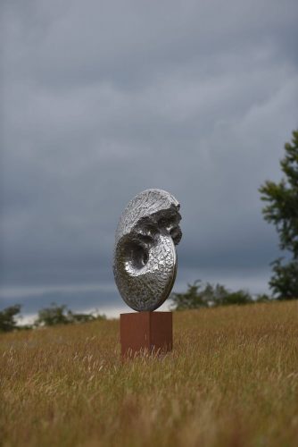 Ammonite sculpture in field of wheat