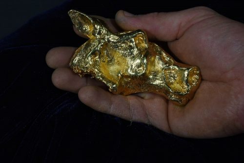 gold primitive horse head in hand