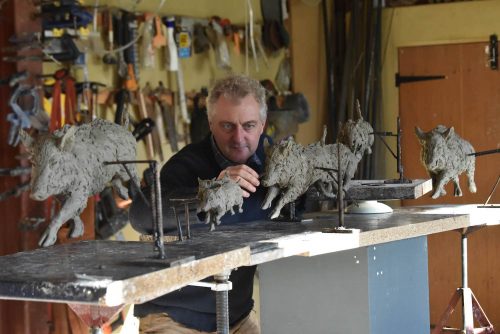 Hamish making wild boar sculptures