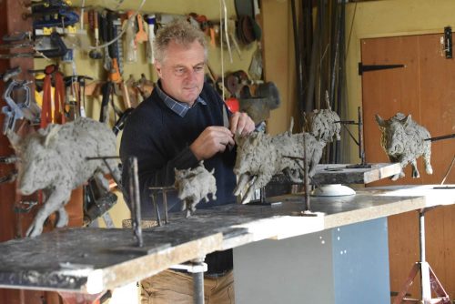 Hamish making wild boar sounder sculptures