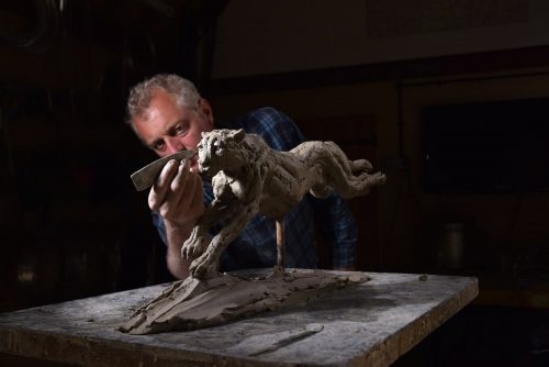 Hamish making clay cheetah sculpture