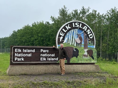 Hamish by entrance sign to Elk Island National Park