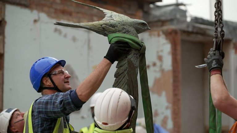 Hamish and construction men installing sculpture