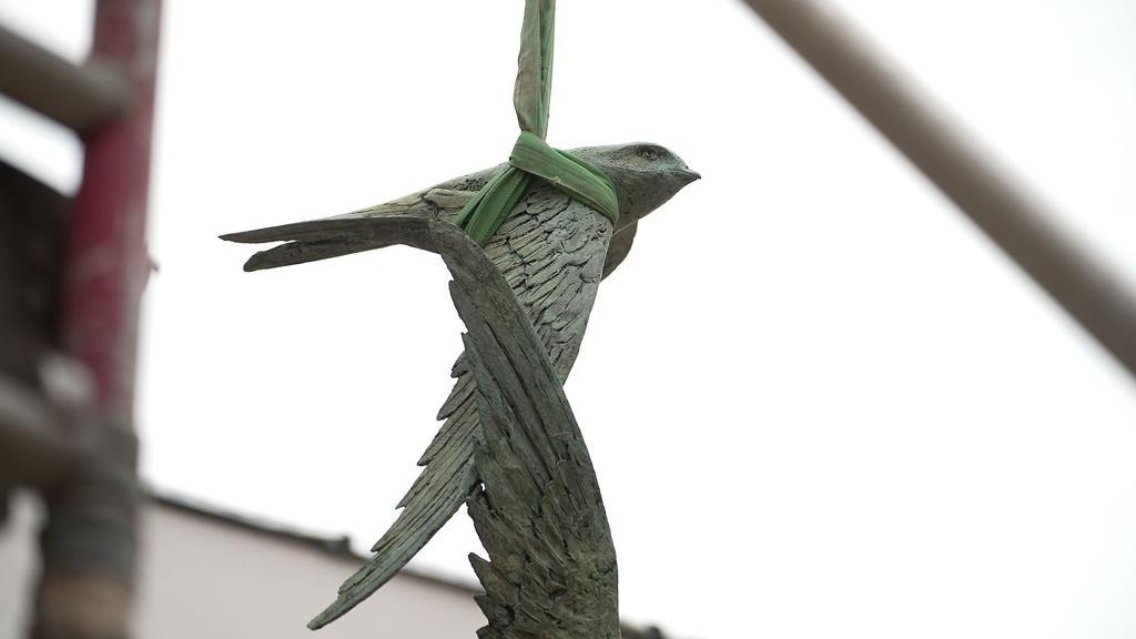 Sculpture hanging from crane