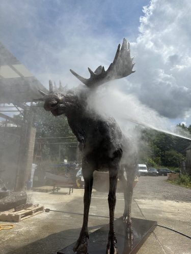 Spraying moose sculpture