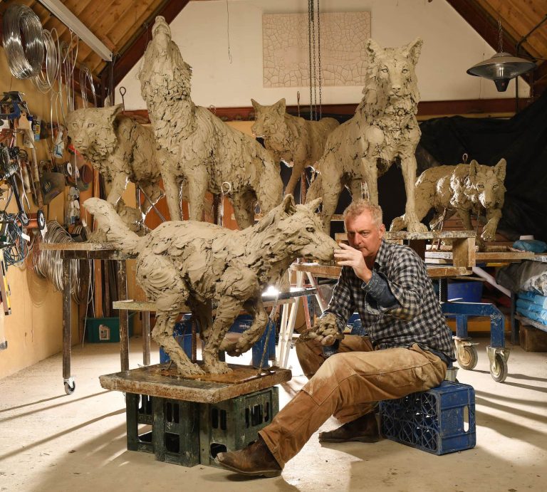 Hamish sculpting clay models of life size wolves