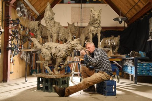 Hamish making wolves sculptures