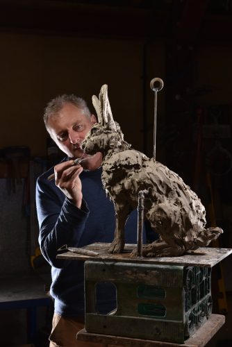 Mackie in studio with hare sculpture