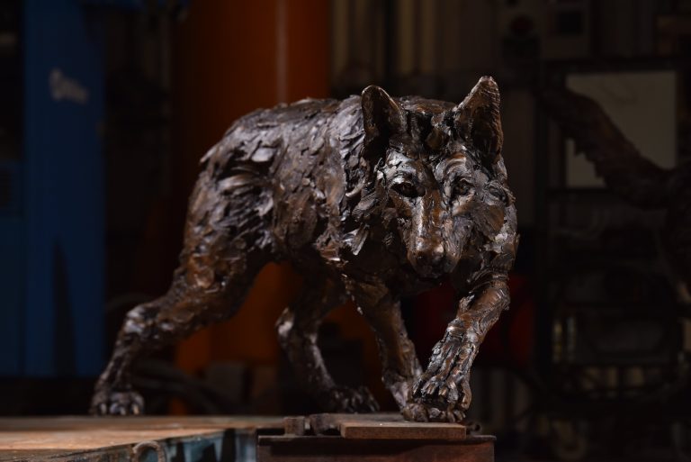 Bronze wolf prowling sculpture