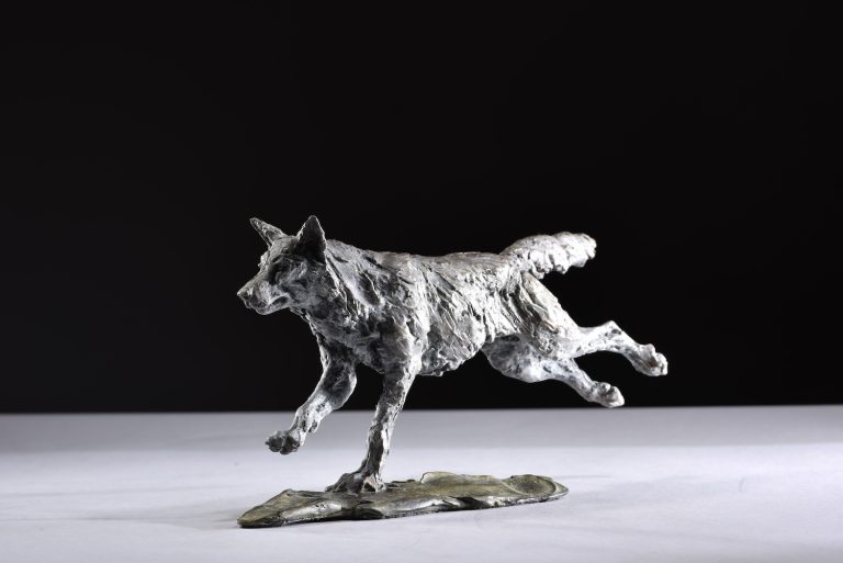 scaled down sculpture of wolf running legs out