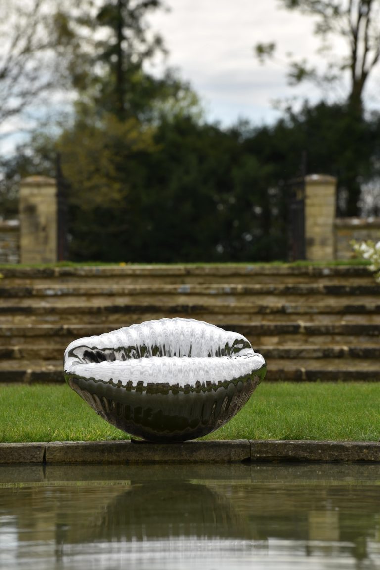 cowrie shell sculpture by pond