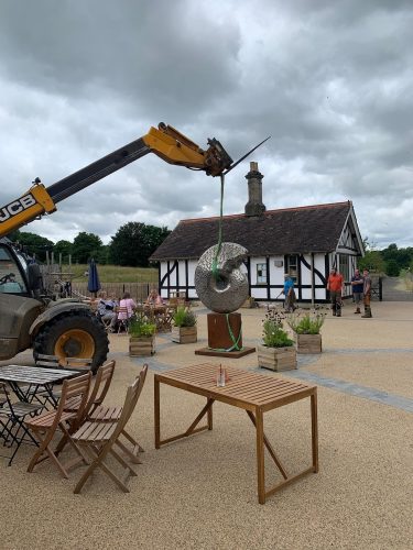 Craning ammonite sculpture into position