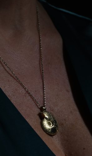 model wearing gold ammonite pendant