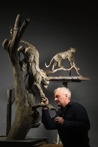 Hamish sculpting leopard climbing down tree