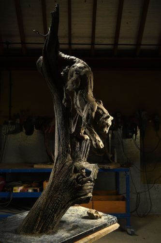 clay model of leopard climbing down a tree