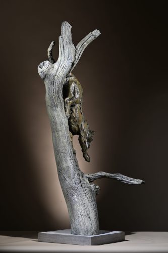 leopard climbing down in bronze